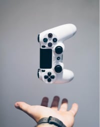 A PS5 controller floating on one hand